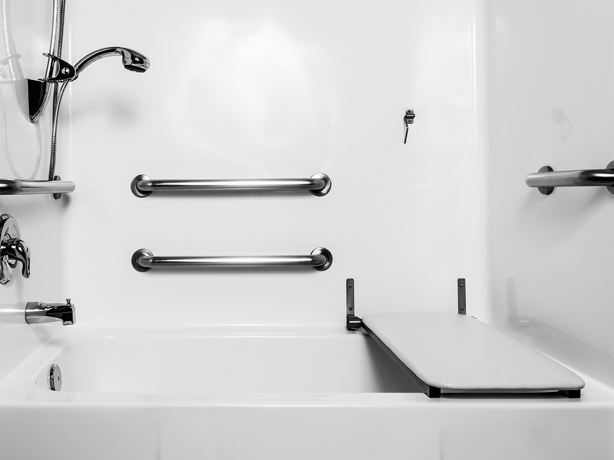 bathtub with various support rails on the wall