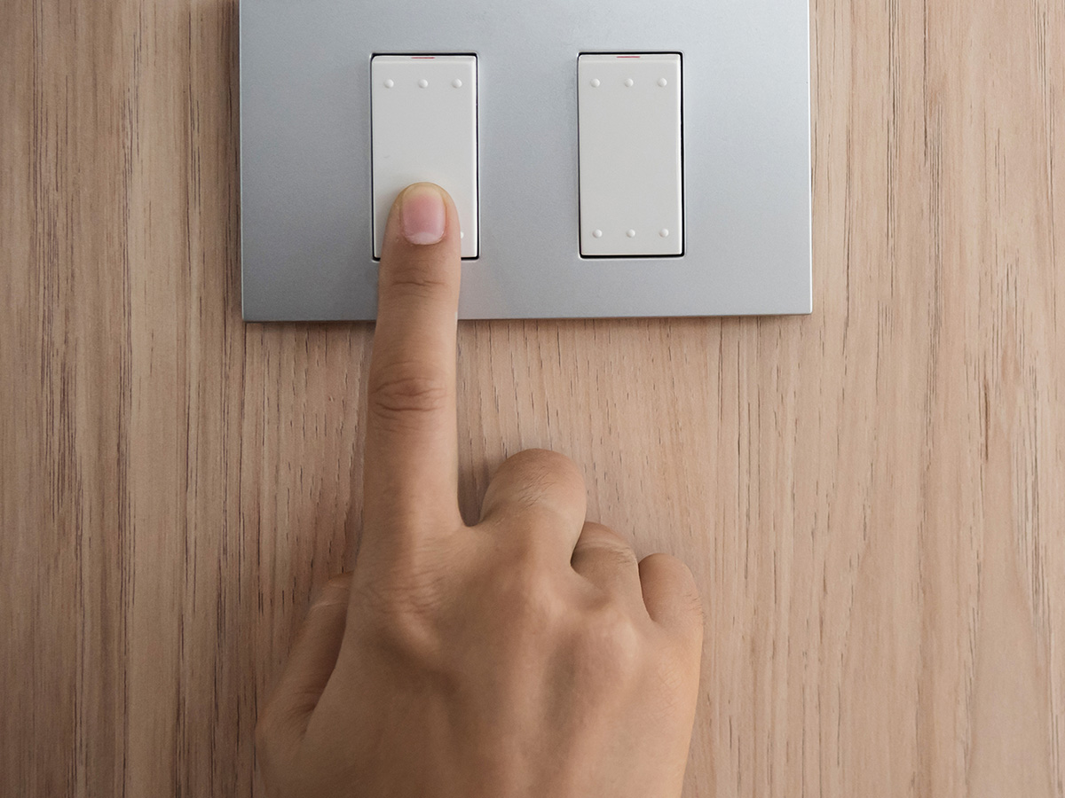 An image of someone turning on a light switch.